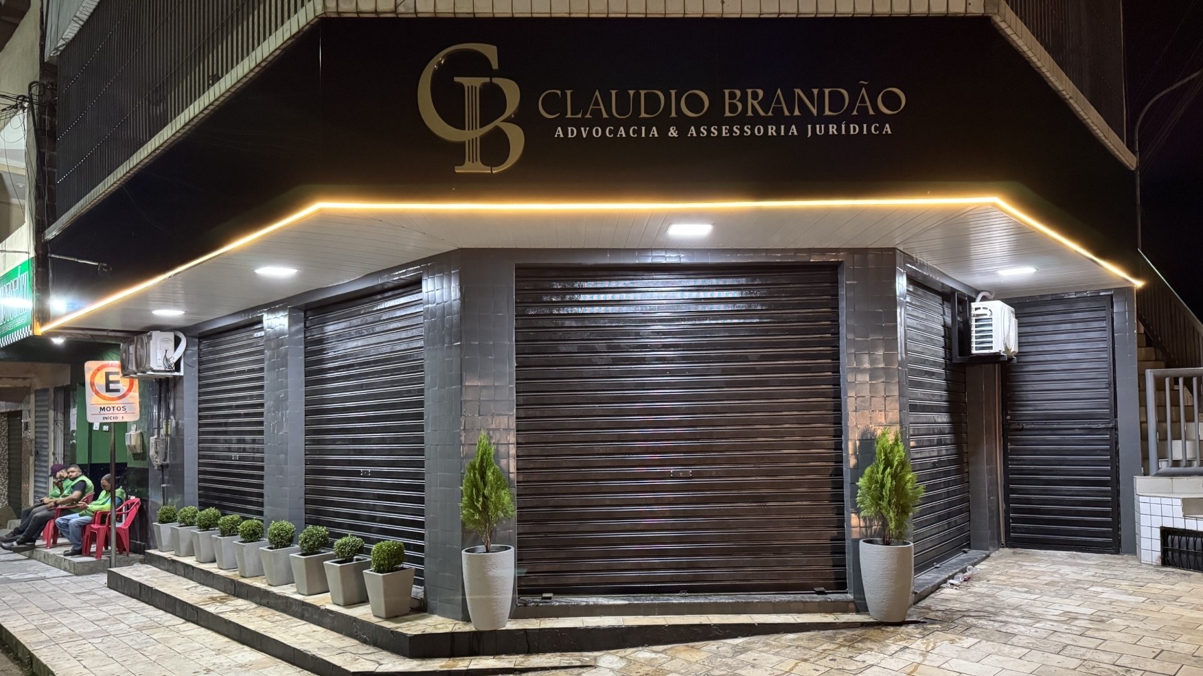 Fachada do escritório Claudio Brandão Advocacia à noite, com letreiro iluminado